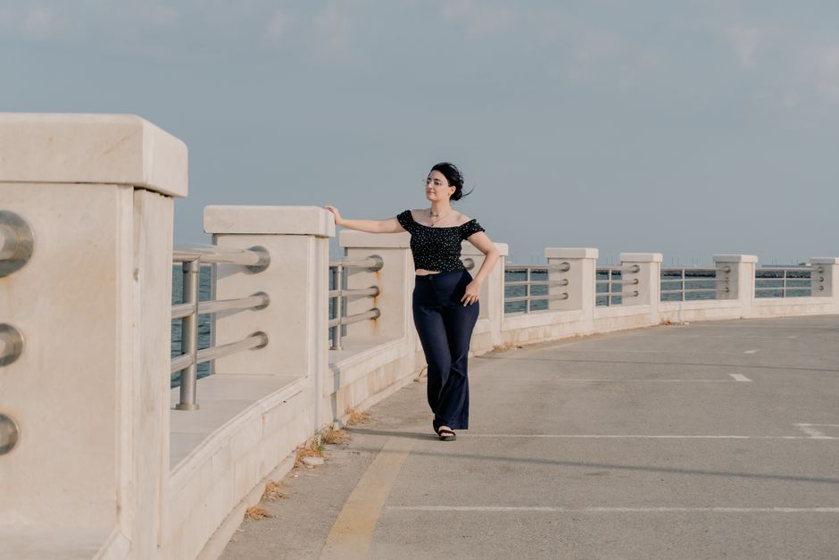 Woman walking along the waterfront promenade in Baku, Azerbaijan on a sunny day.