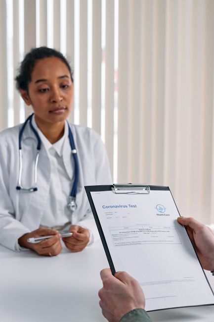 A doctor discusses coronavirus test results with a patient in a medical office.