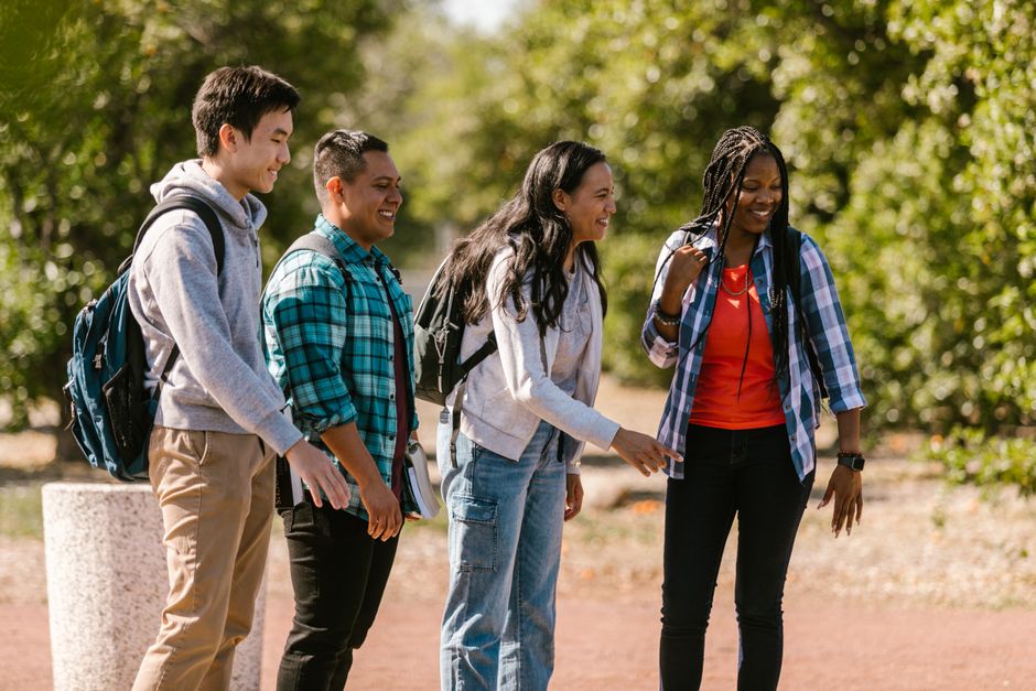 Cheerful group of diverse students chatting outdoors with backpacks. Perfect for education and lifestyle themes.