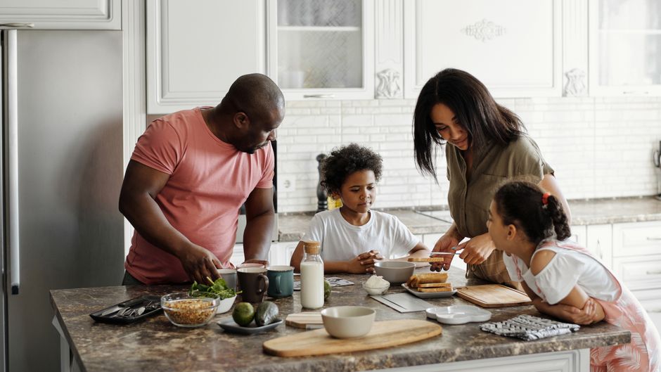 A family cooking together in the kitchen, promoting family bonds and healthy living.