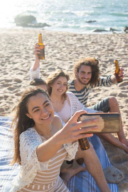 Group of friends taking a selfie on a sunny beach in Portugal. Perfect summer moment.