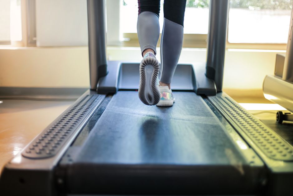 Feet walking on a treadmill belt