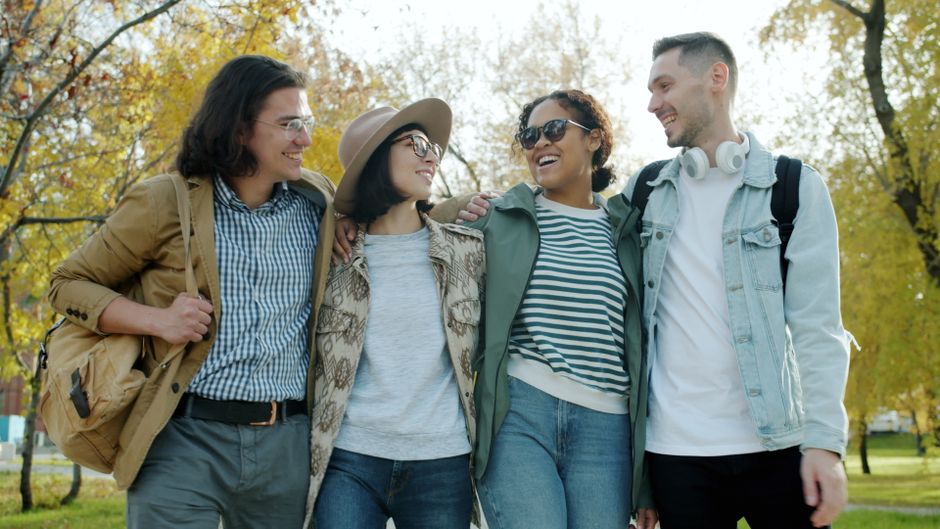 Group of friends enjoying a sunny autumn day together in a park.
