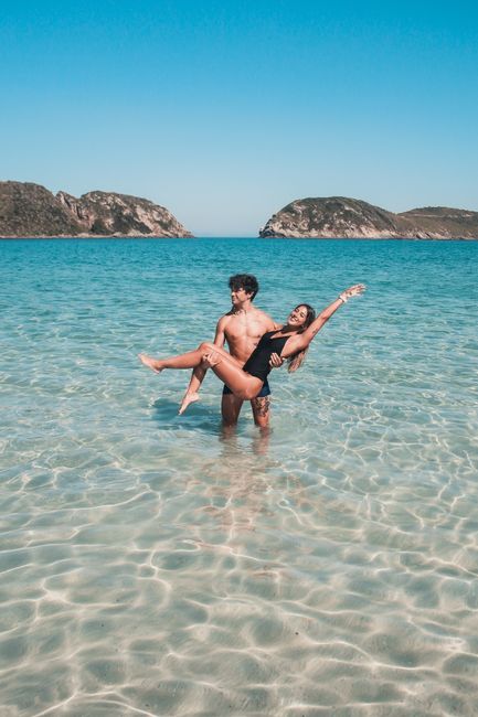 A young couple enjoying a summer day at a tropical beach with clear turquoise waters.