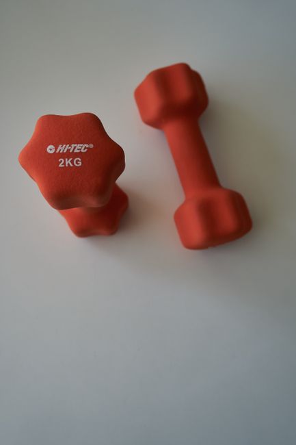 Orange 2kg dumbbells with brand label on white background, fitness gear.